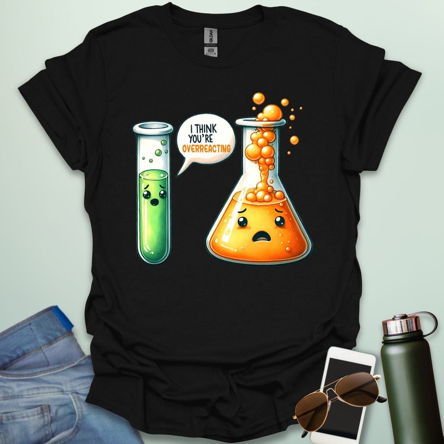 BLACK t-shirt with a graphic of two test tubes and a beaker on a light gray background. The test tube says, "I THINK YOU'RE OVERREACTING"