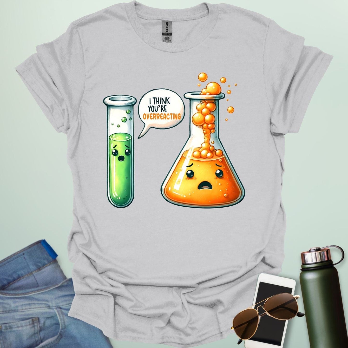 Ice Grey t-shirt with a graphic of two test tubes and a beaker on a light gray background. The test tube says, "I THINK YOU'RE OVERREACTING"