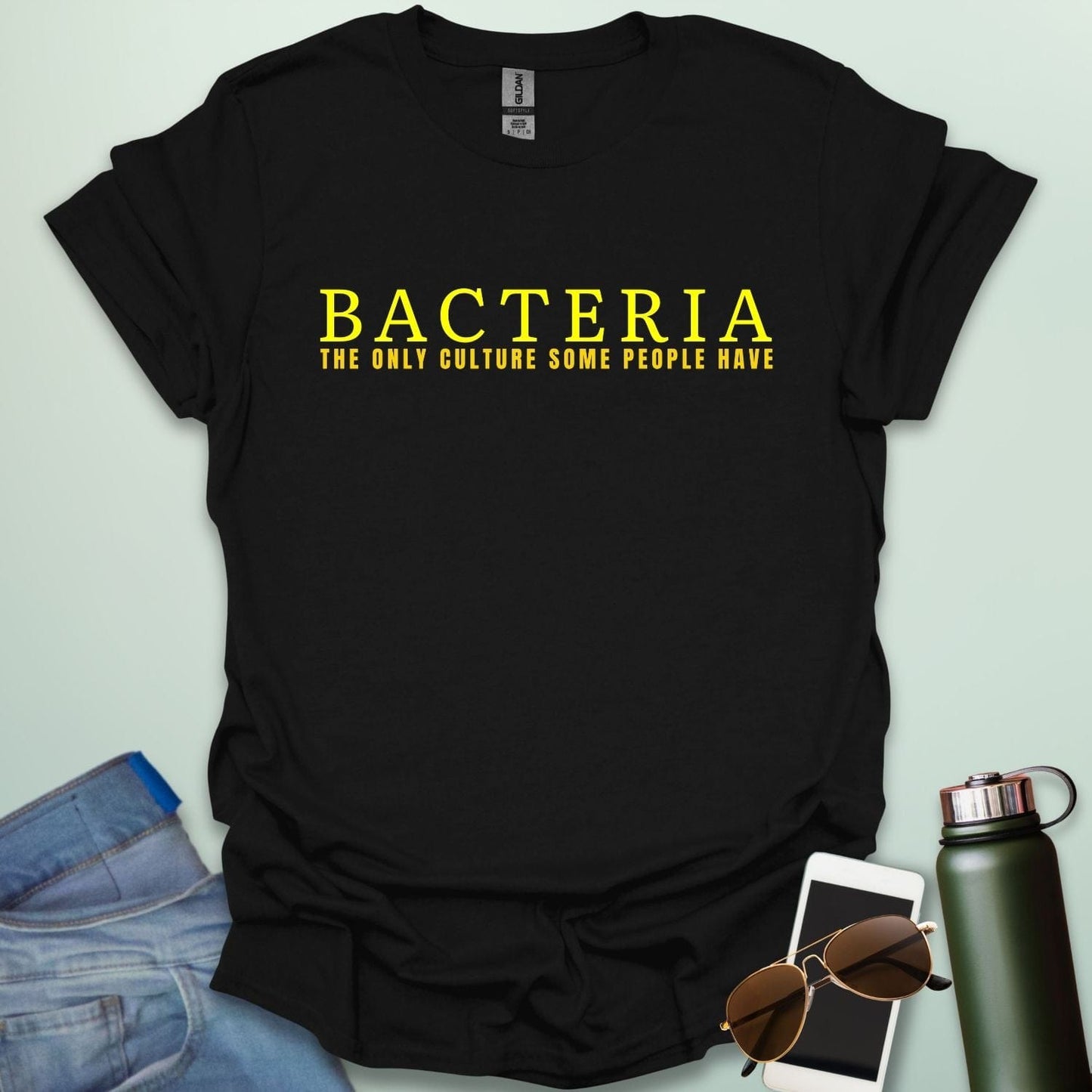 A black t-shirt with the text 'BACTERIA THE ONLY CULTURE SOME PEOPLE HAVE' in yellow, bold font.