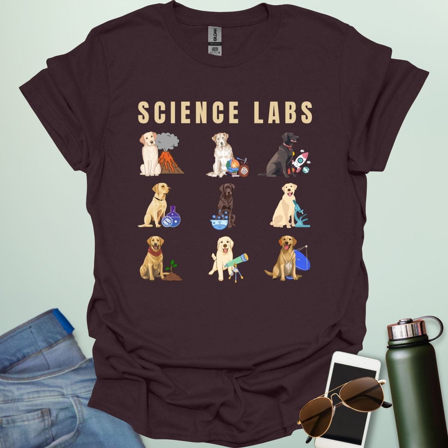 A dark chocolate t-shirt with the text 'SCIENCE LABS' and a grid of nine illustrations of Labrador Retrievers in various science-themed scenarios.