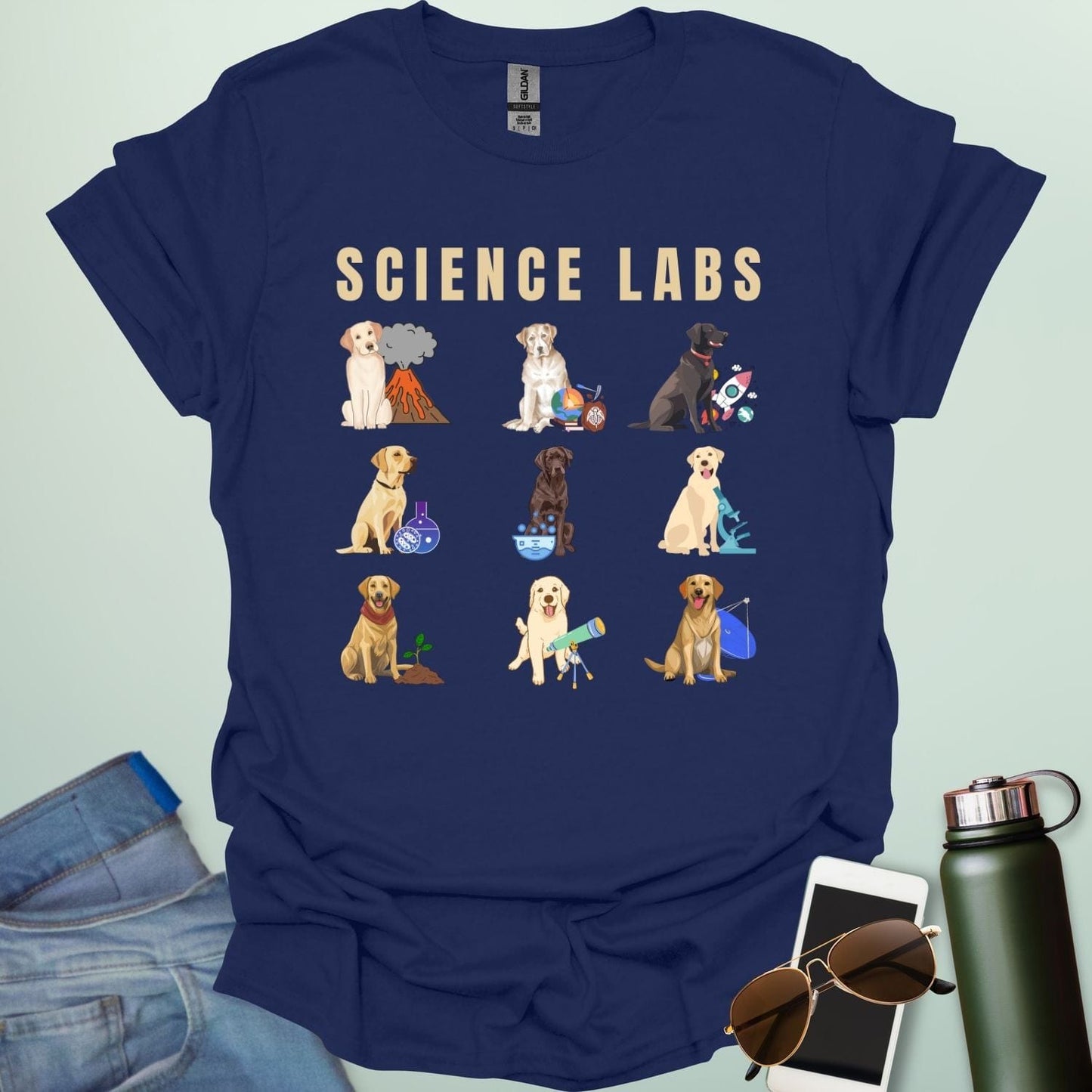 A navy blue t-shirt with the text 'SCIENCE LABS' and a grid of nine illustrations of Labrador Retrievers in various science-themed scenarios.