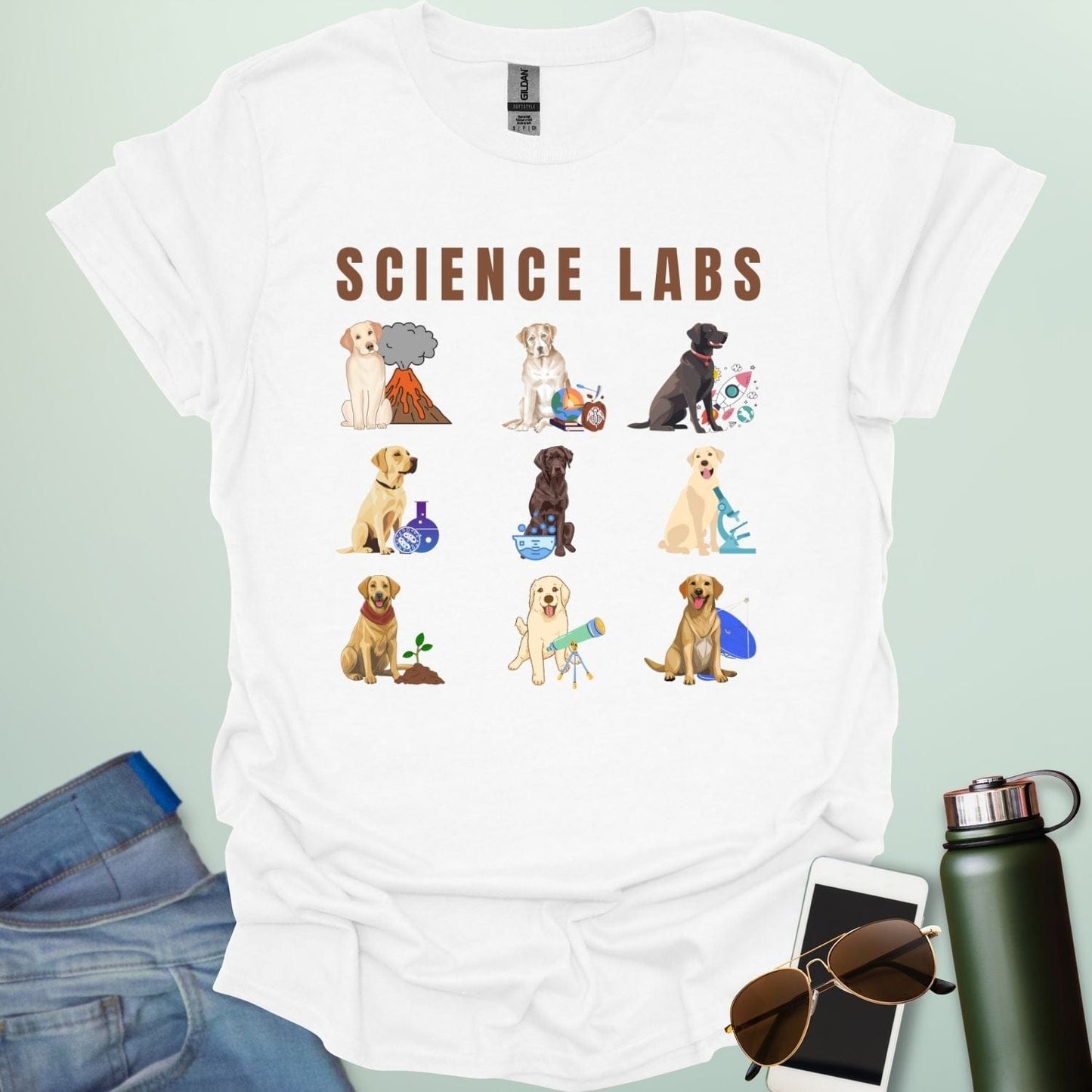 A white t-shirt with the text 'SCIENCE LABS' and a grid of nine illustrations of Labrador Retrievers in various science-themed scenarios.