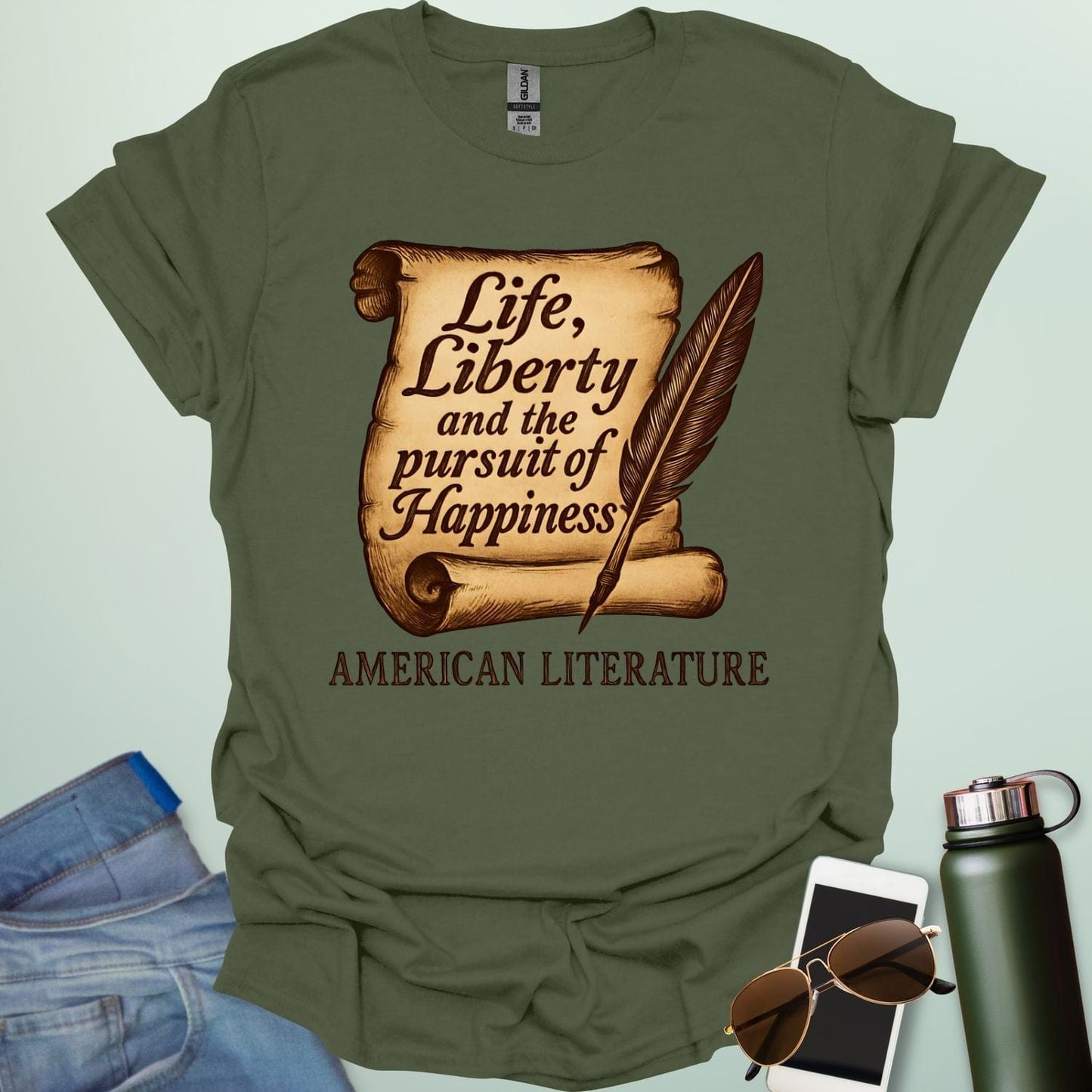 A military green t-shirt with a vintage-style scroll and quill pen, and the text 'Life, Liberty and the pursuit of Happiness' and 'American Literature.'