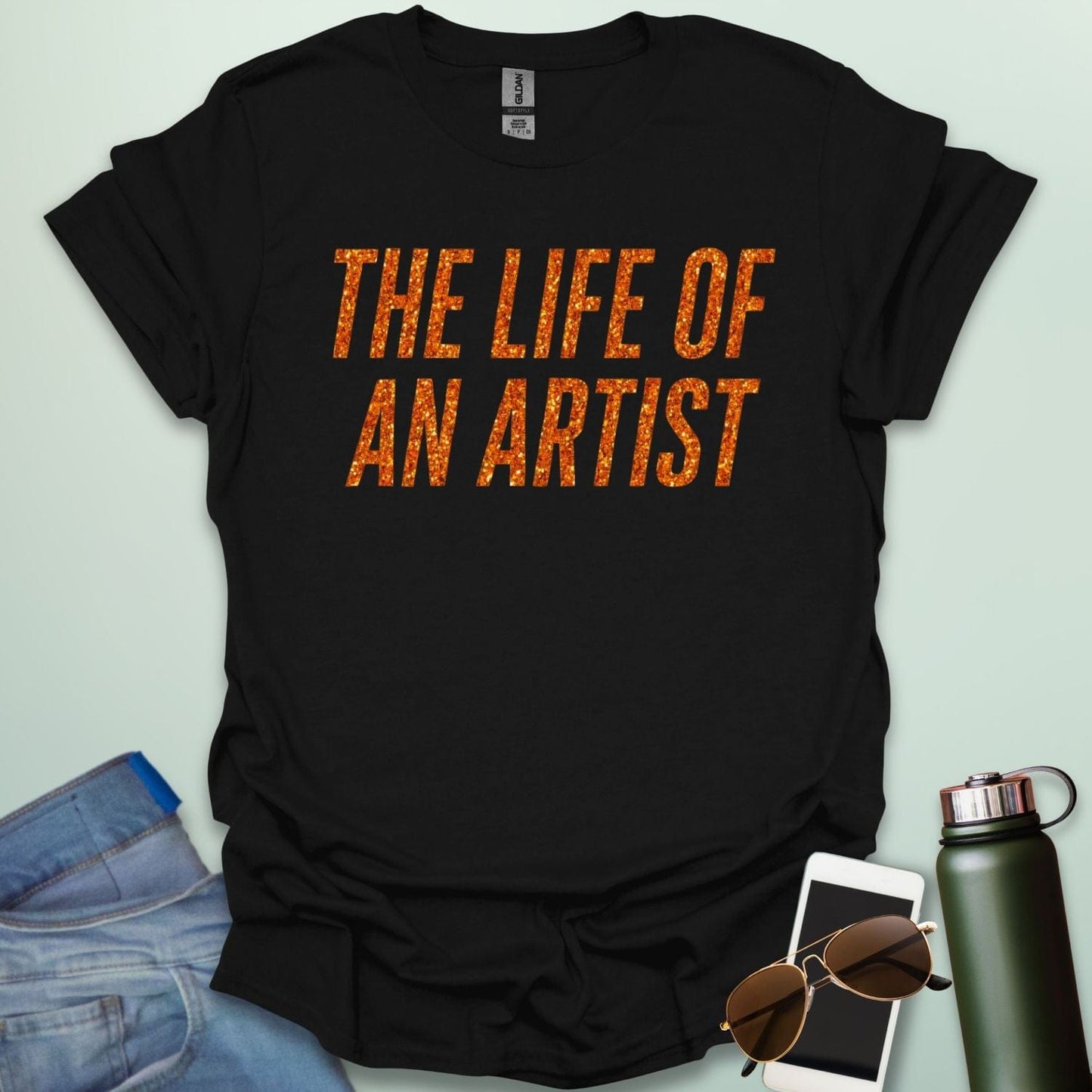 A black t-shirt with the bold, distressed text 'THE LIFE OF AN ARTIST.'