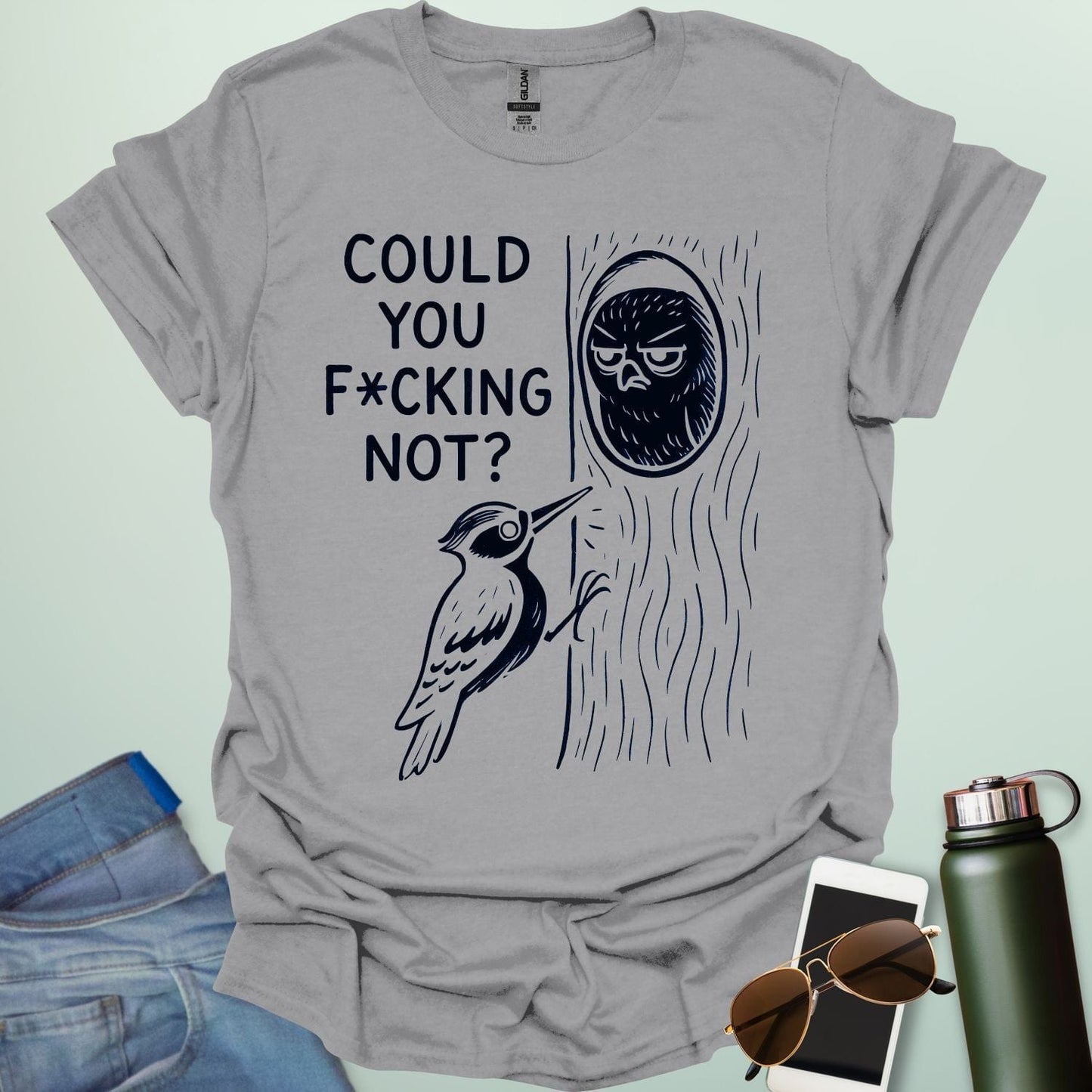 Minimal illustration of an irritated owl peeking from its tree burrow while a woodpecker pecks at the trunk, with bold text reading “COULD YOU F*CKING NOT?” on a dark background.