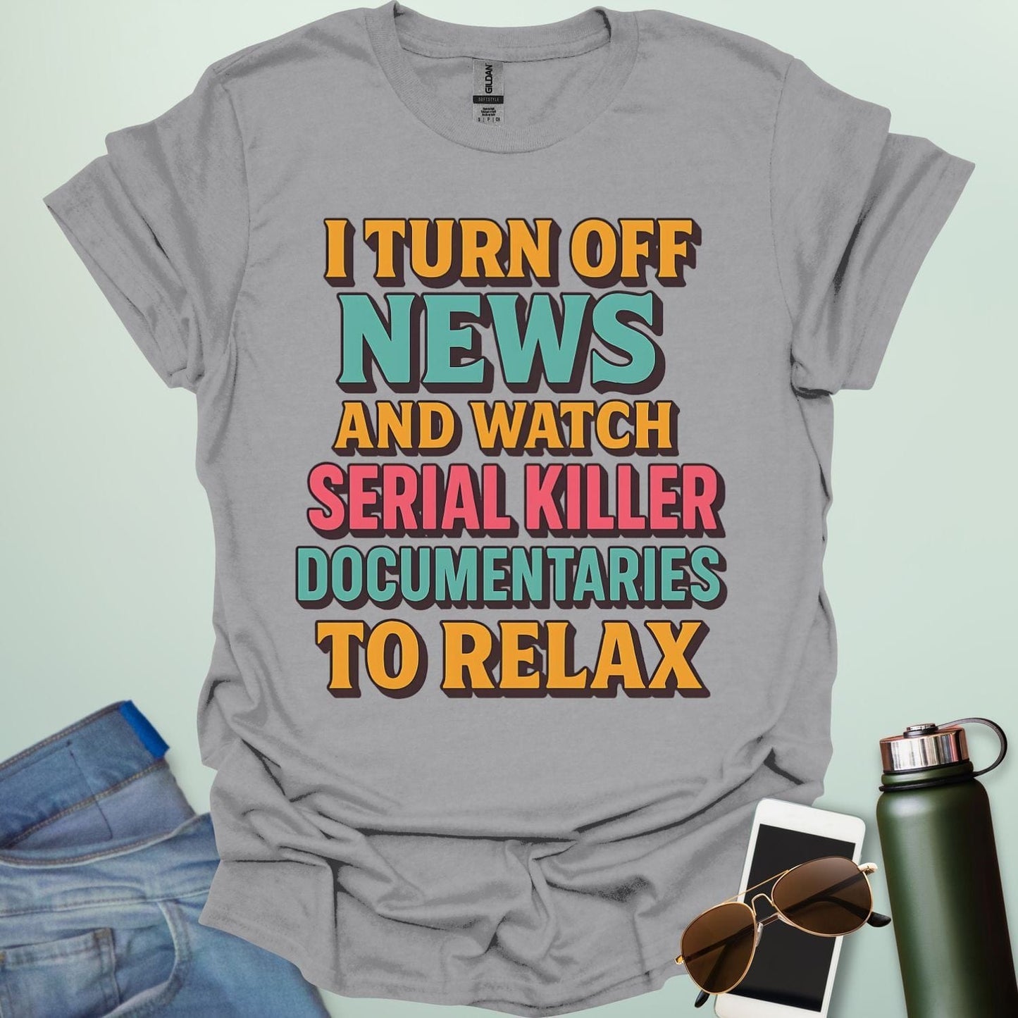 ‘I Turn Off News & Watch Serial Killer Documentaries To Relax’ t-shirt with bold typography — humorous true crime statement tee.