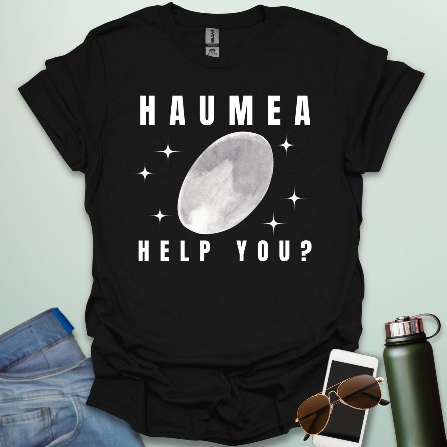 "A black t-shirt with a drawing of the dwarf planet Haumea and the text 'HAUMEA HELP YOU?'
