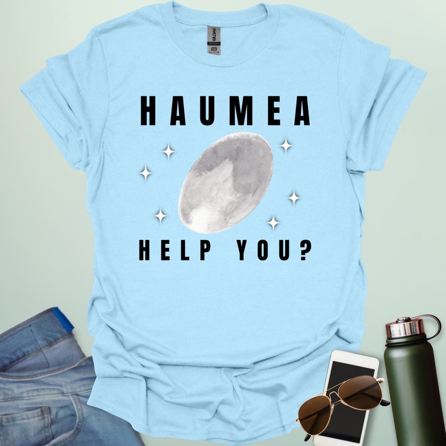 "A light blue t-shirt with a drawing of the dwarf planet Haumea and the text 'HAUMEA HELP YOU?'