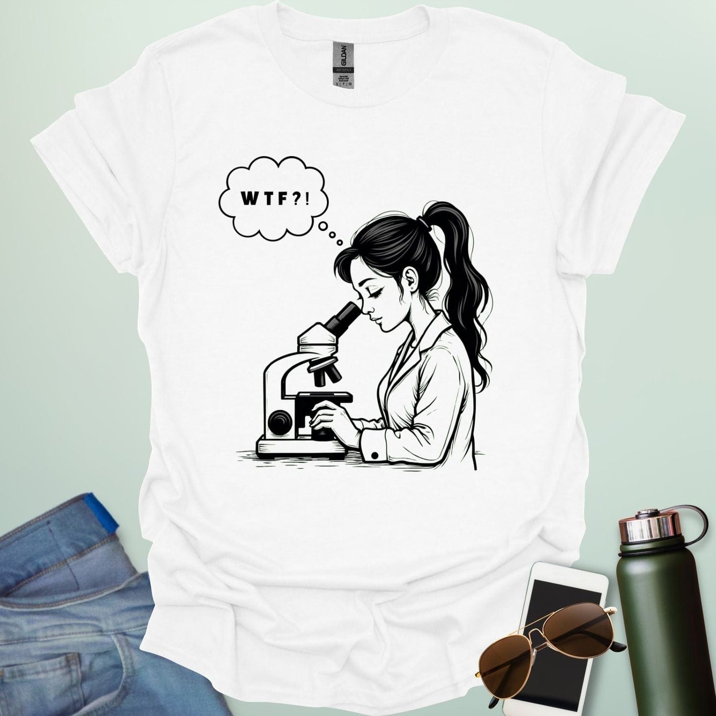 A funny t-shirt for scientists with a line drawing of a woman looking through a microscope and a thought bubble with the text 'WTF?!'