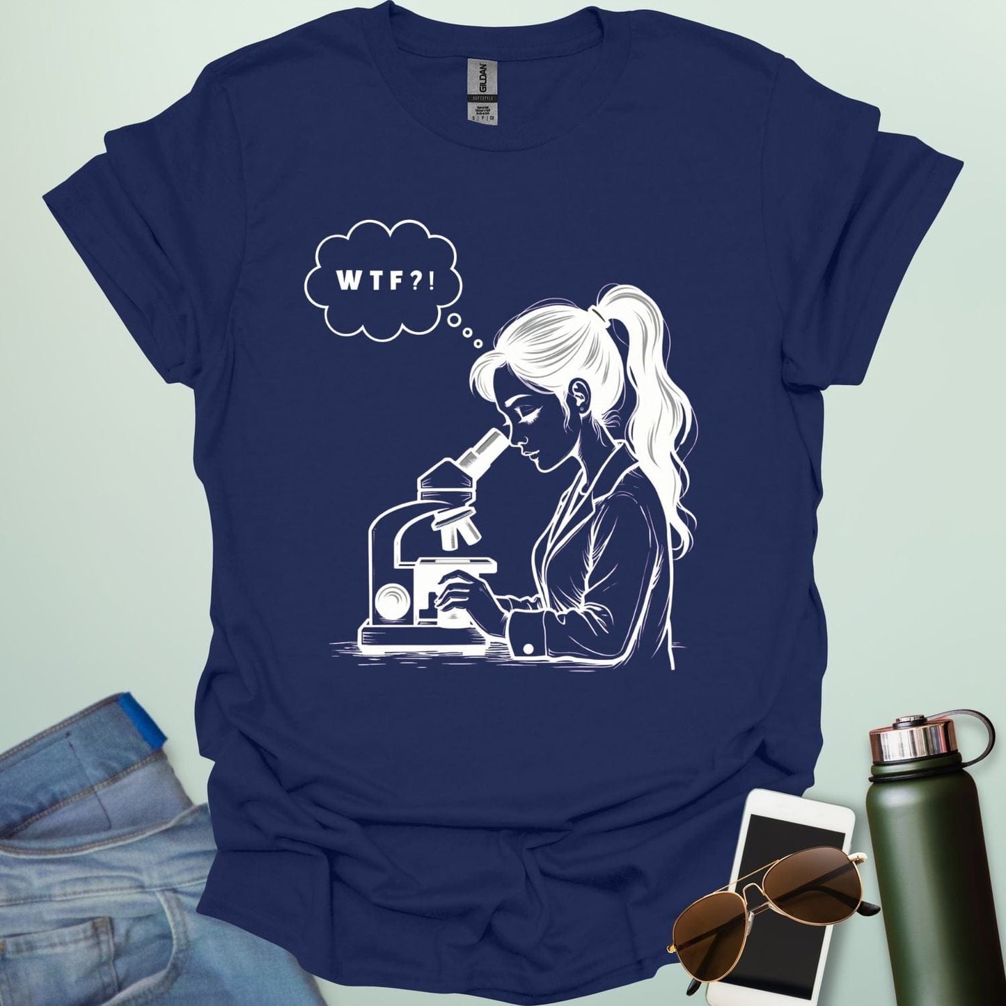 A funny t-shirt for scientists with a line drawing of a woman looking through a microscope and a thought bubble with the text 'WTF?!'