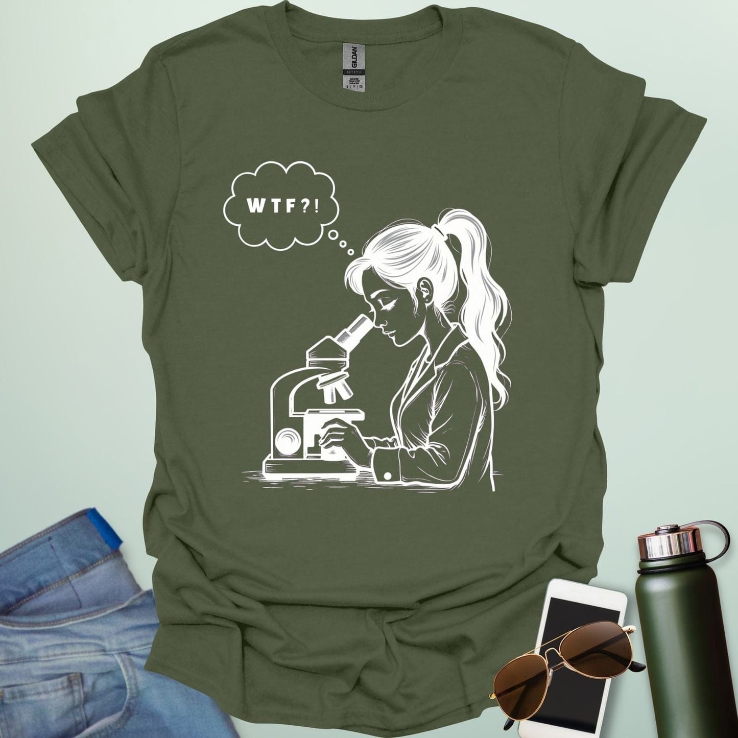 A funny t-shirt for scientists with a line drawing of a woman looking through a microscope and a thought bubble with the text 'WTF?!'