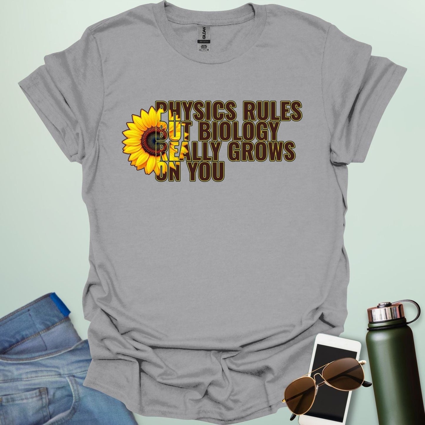 A funny biology t-shirt with a sunflower and the text 'Biology Really Grows On You,' a witty pun for biology teachers and plant lovers.