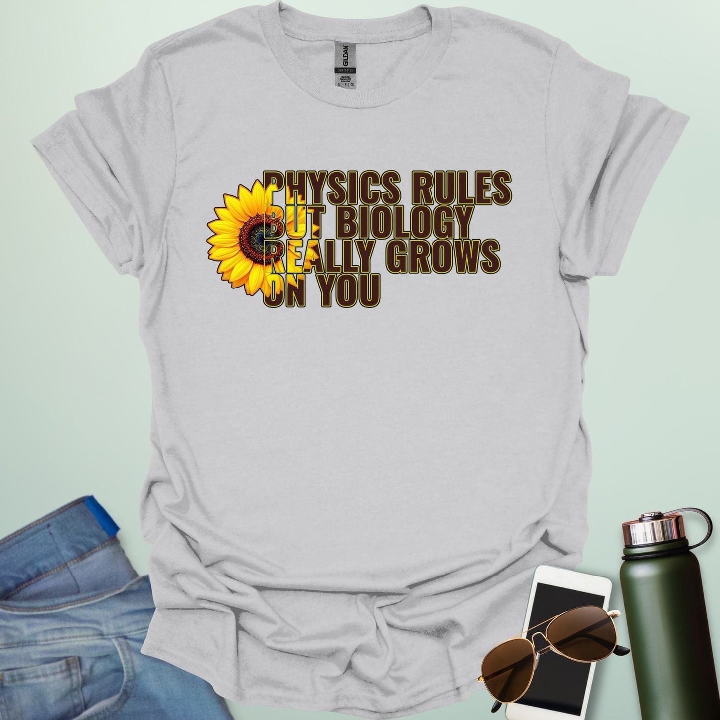 A funny biology t-shirt with a sunflower and the text 'Biology Really Grows On You,' a witty pun for biology teachers and plant lovers.