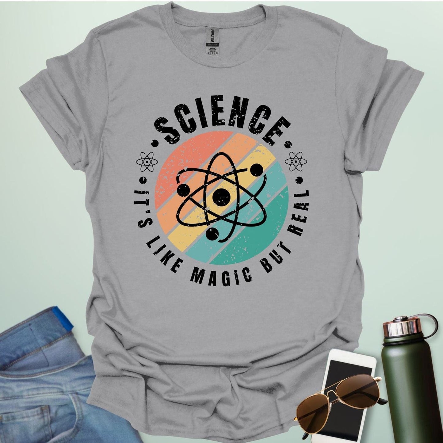 T-shirt with a clean design featuring an atom symbol and the quote 'Science - It's like magic but real'.