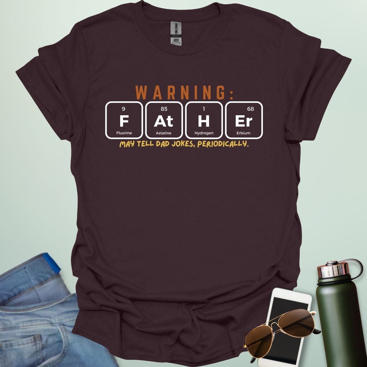 A funny periodic table t-shirt for fathers, using the elements Fluorine, Astatine, Hydrogen, and Erbium to spell 'FAtHEr'. The design says 'WARNING: FATHER MAY TELL DAD JOKES, PERIODICALLY.'