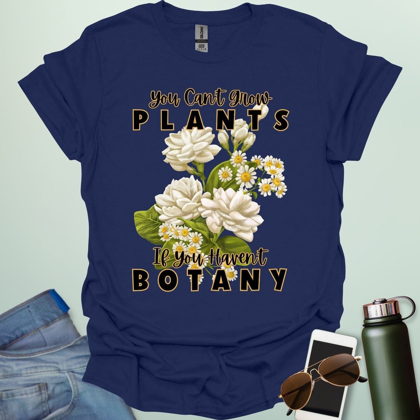 A charming t-shirt with a floral design and the text 'You Can't Grow Plants If You Haven't Botany,' a witty pun for botanists and gardeners.