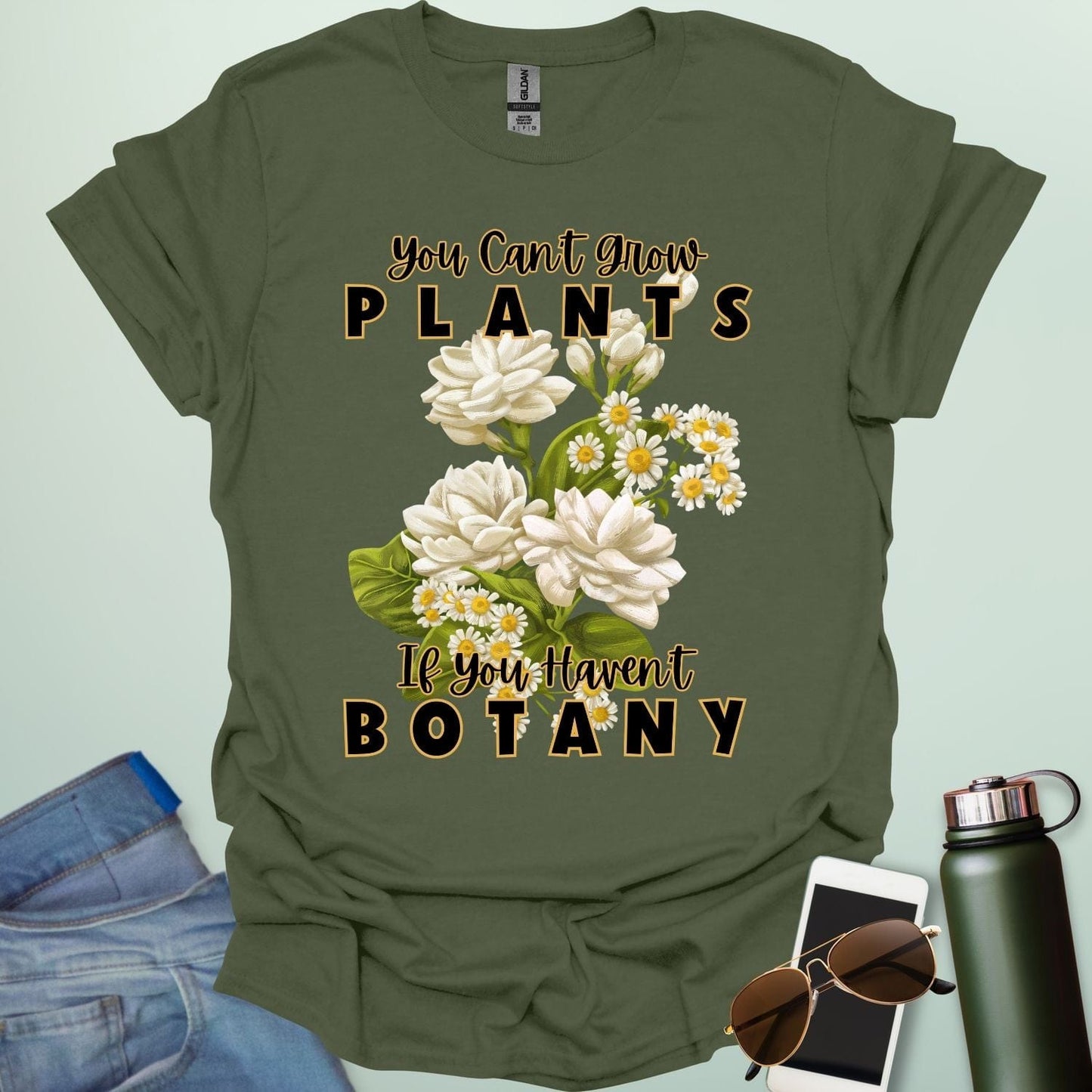 A charming t-shirt with a floral design and the text 'You Can't Grow Plants If You Haven't Botany,' a witty pun for botanists and gardeners.