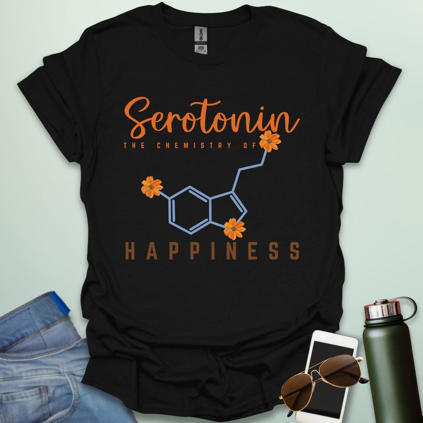 The word 'Serotonin' in cursive orange font above the text 'THE CHEMISTRY OF' in smaller orange font, above the chemical structure of serotonin in light blue with three orange flowers incorporated into the bonds. Below the chemical structure is the word 'HAPPINESS' in bold orange font.