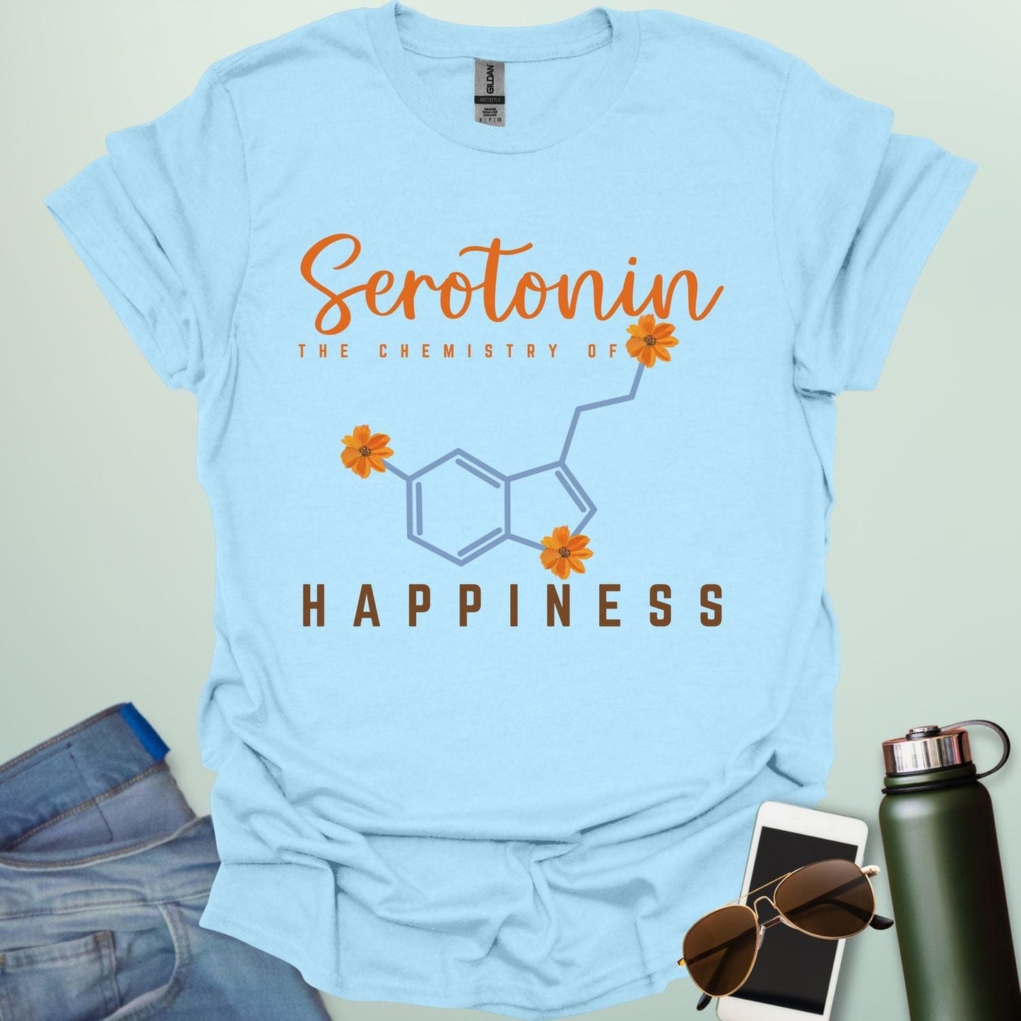 The word 'Serotonin' in cursive orange font above the text 'THE CHEMISTRY OF' in smaller orange font, above the chemical structure of serotonin in light blue with three orange flowers incorporated into the bonds. Below the chemical structure is the word 'HAPPINESS' in bold orange font.