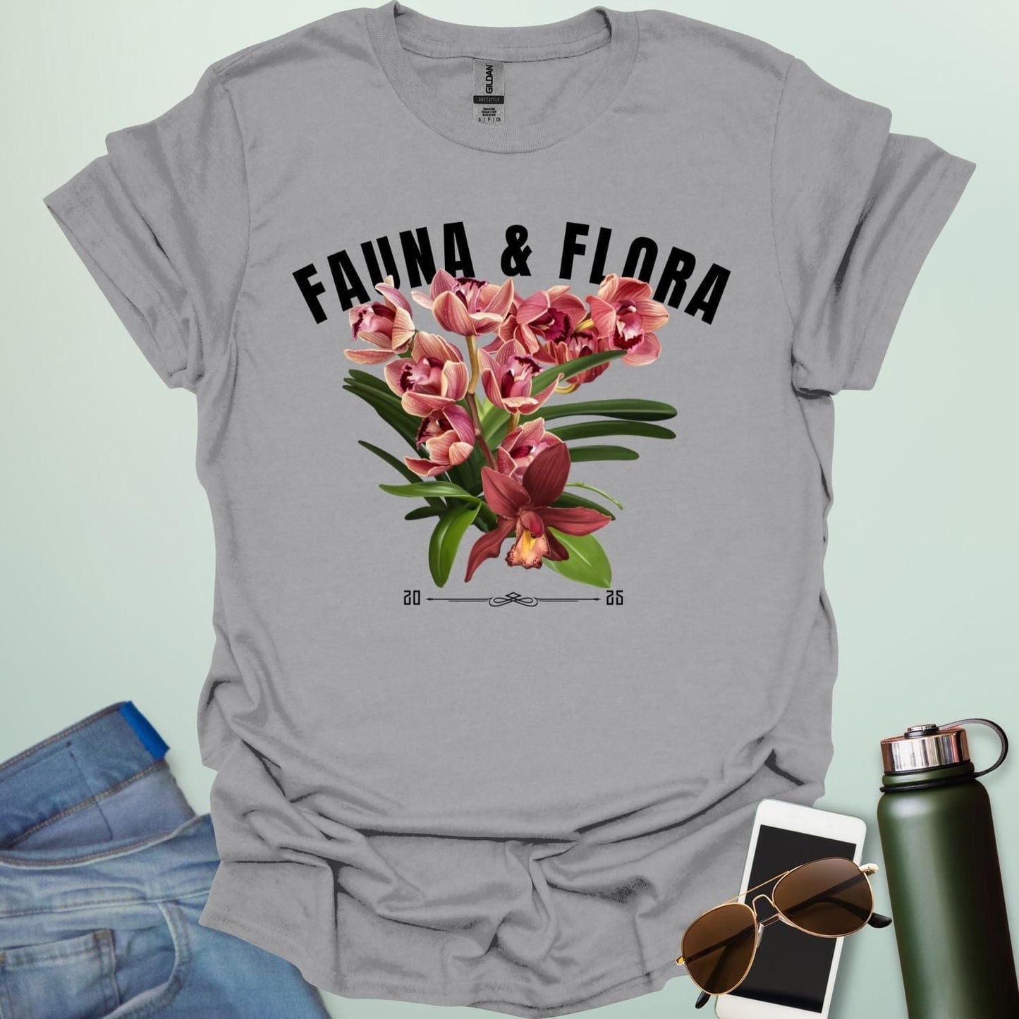 A beautiful t-shirt with a detailed illustration of a pink orchid and green leaves, perfect for gardeners and nature lovers.