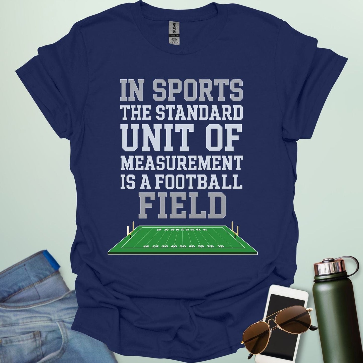 A navy bluet-shirt with the text 'IN SPORTS THE STANDARD UNIT OF MEASUREMENT IS A FOOTBALL FIELD' above an illustration of a football field.