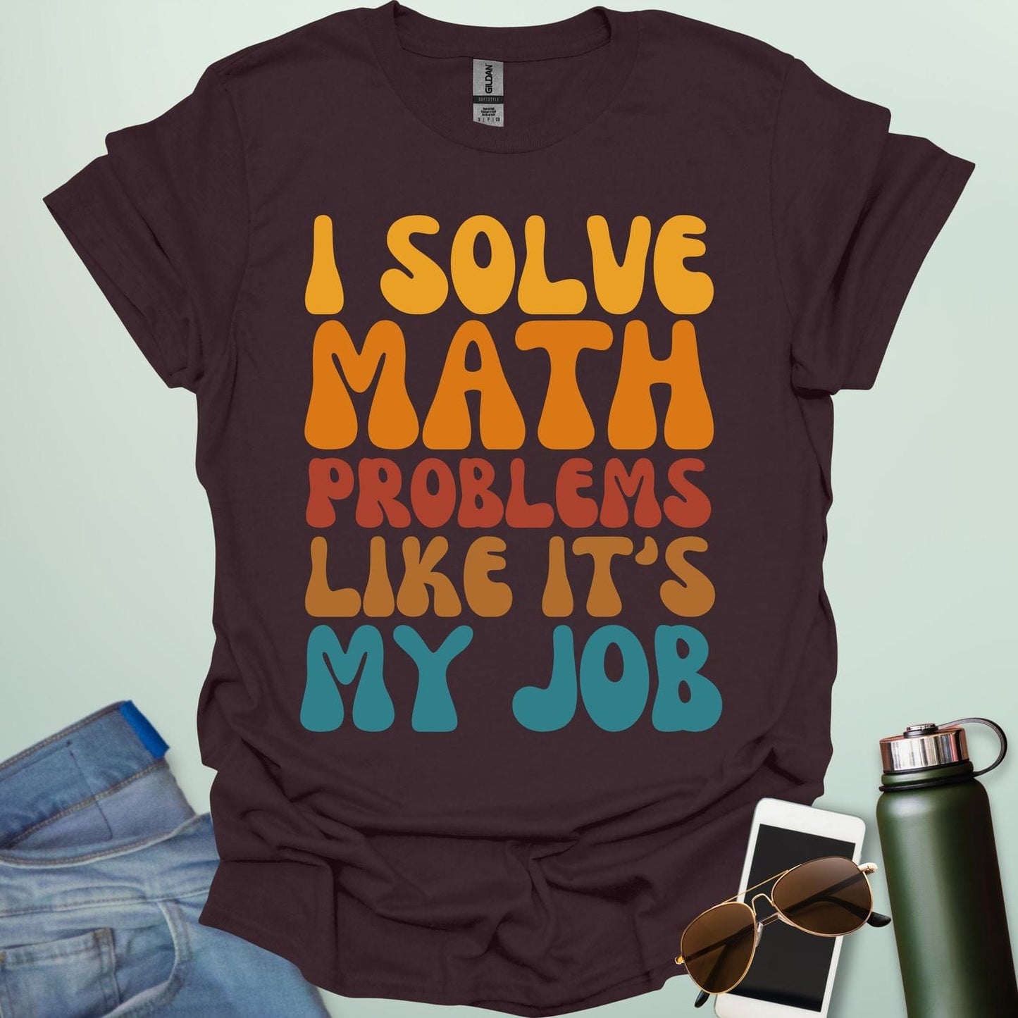 A t-shirt with the text 'I SOLVE MATH PROBLEMS LIKE IT'S MY JOB' printed in a retro, colorful, and bold font.