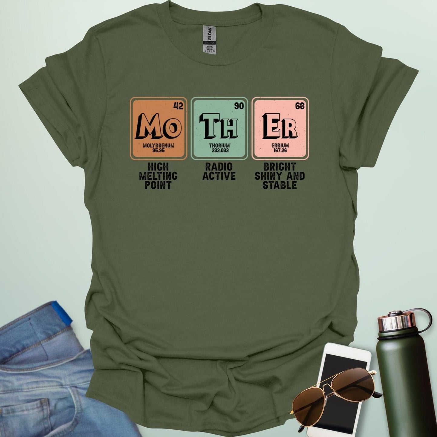 A military green t-shirt design with three periodic table elements: Mo (Molybdenum), Th (Thorium), and Er (Erbium), with humorous descriptions underneath.