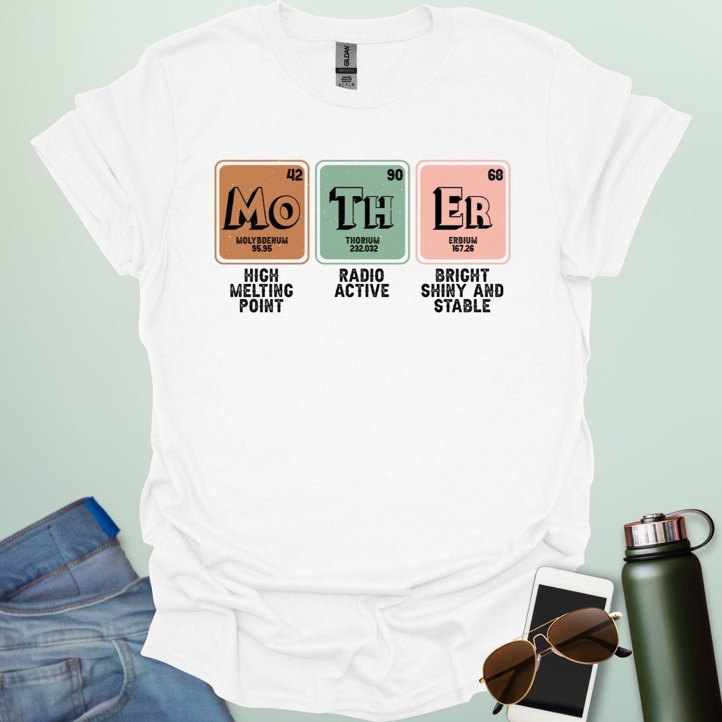 A white t-shirt design with three periodic table elements: Mo (Molybdenum), Th (Thorium), and Er (Erbium), with humorous descriptions underneath.