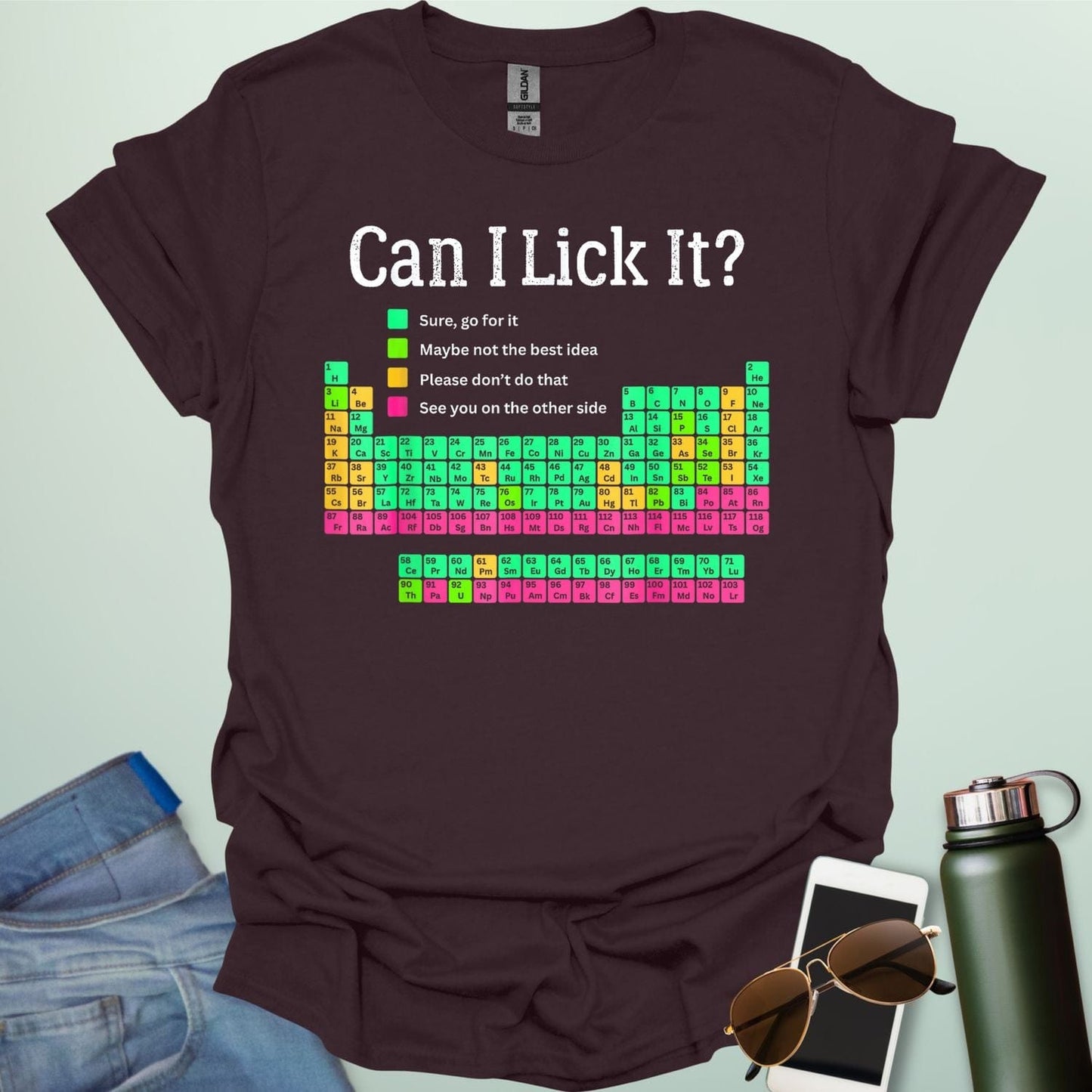 Can I Lick It?' periodic table t-shirt with a color-coded chart of elements and a funny chemistry warning.