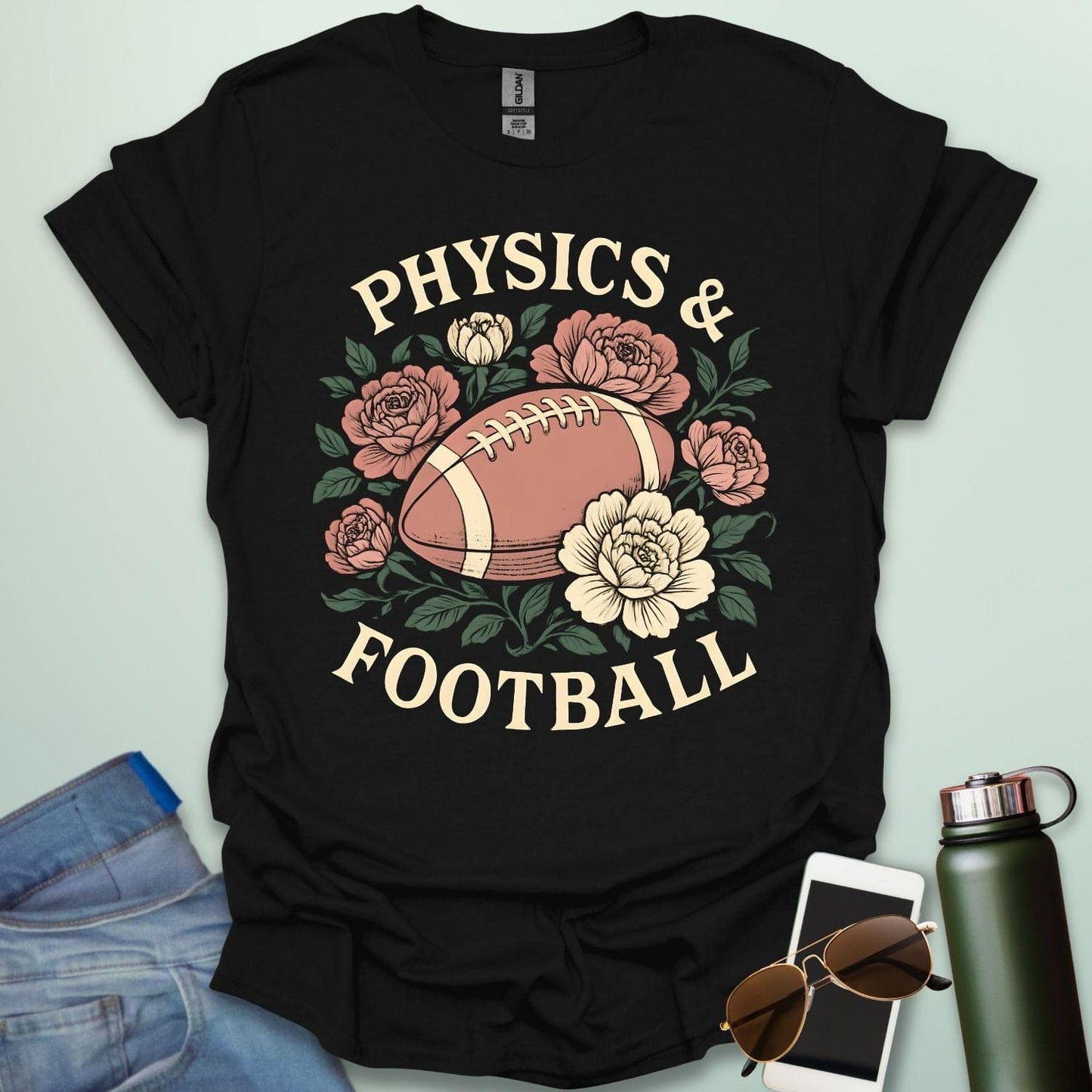 A black t-shirt with a vintage illustration of a football surrounded by flowers and the text 'PHYSICS & FOOTBALL.'