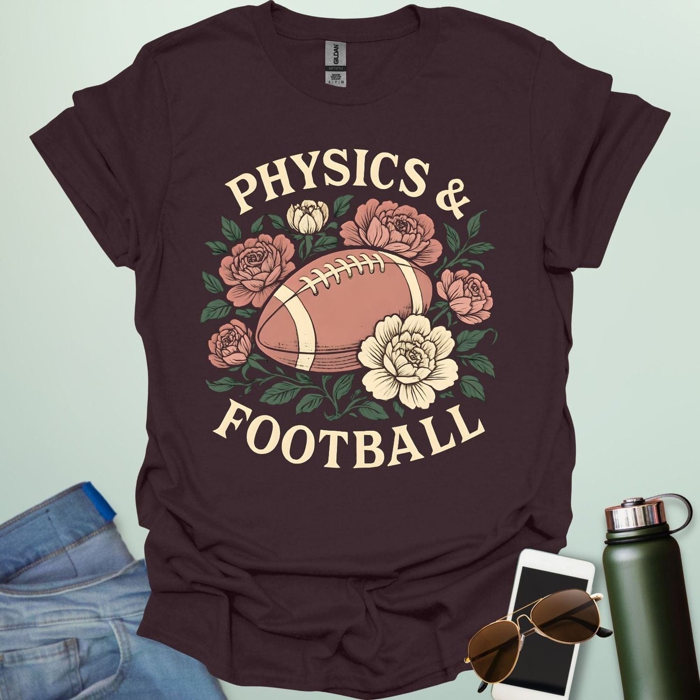 A dark chocolate t-shirt with a vintage illustration of a football surrounded by flowers and the text 'PHYSICS & FOOTBALL.'