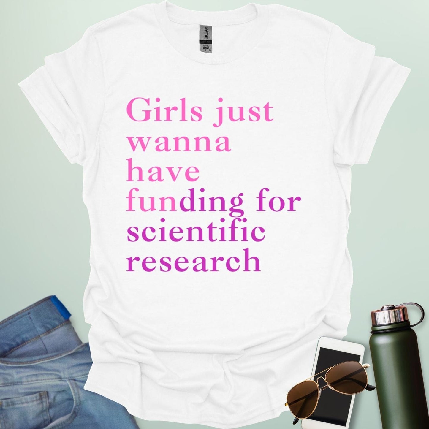 A white t-shirt with the text 'Girls just wanna have funding for scientific research' in a pink serif font.