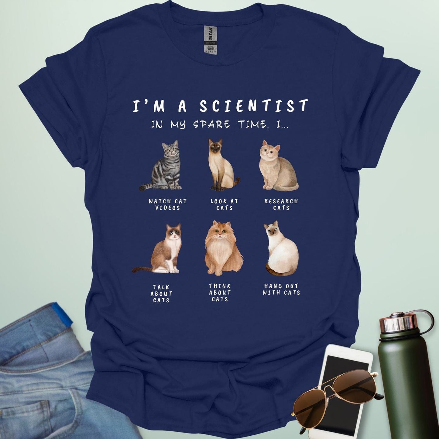 Navy blue t-shirt with cat-themed text and illustrations on a light green background