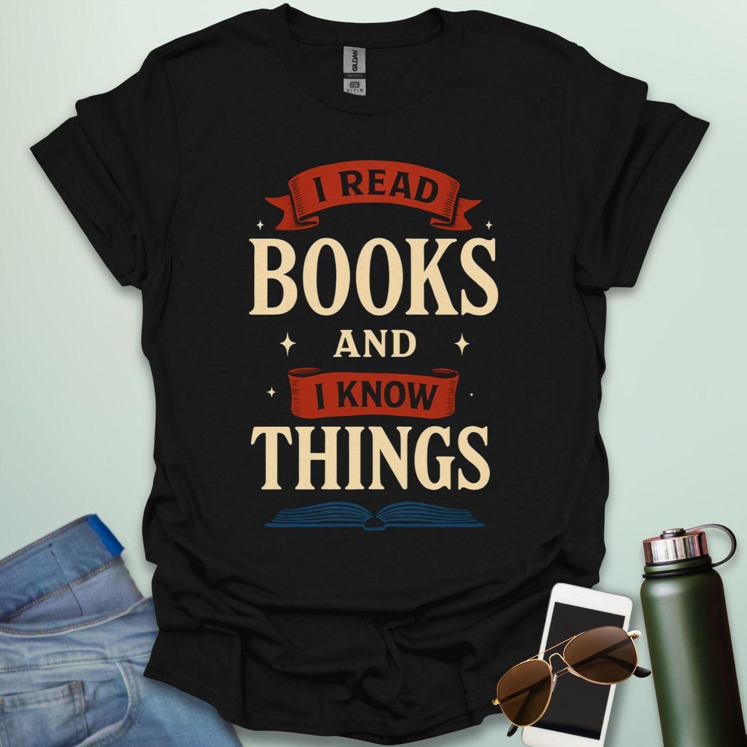 A black t-shirt with the text 'I READ BOOKS AND I KNOW THINGS' and a graphic of an open book below it.