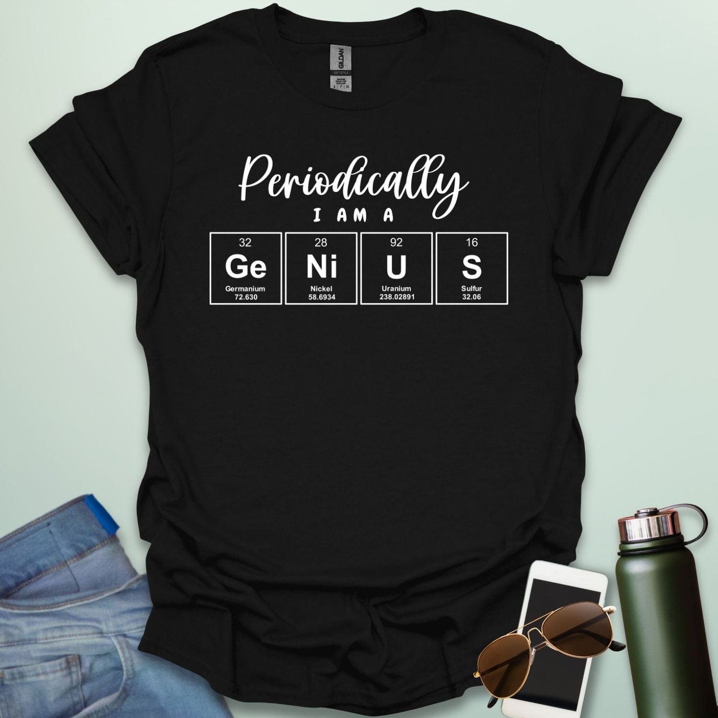 A black t-shirt with the text 'Periodically I Am A Genius,' spelled out with the periodic table elements Ge, Ni, U, and S.