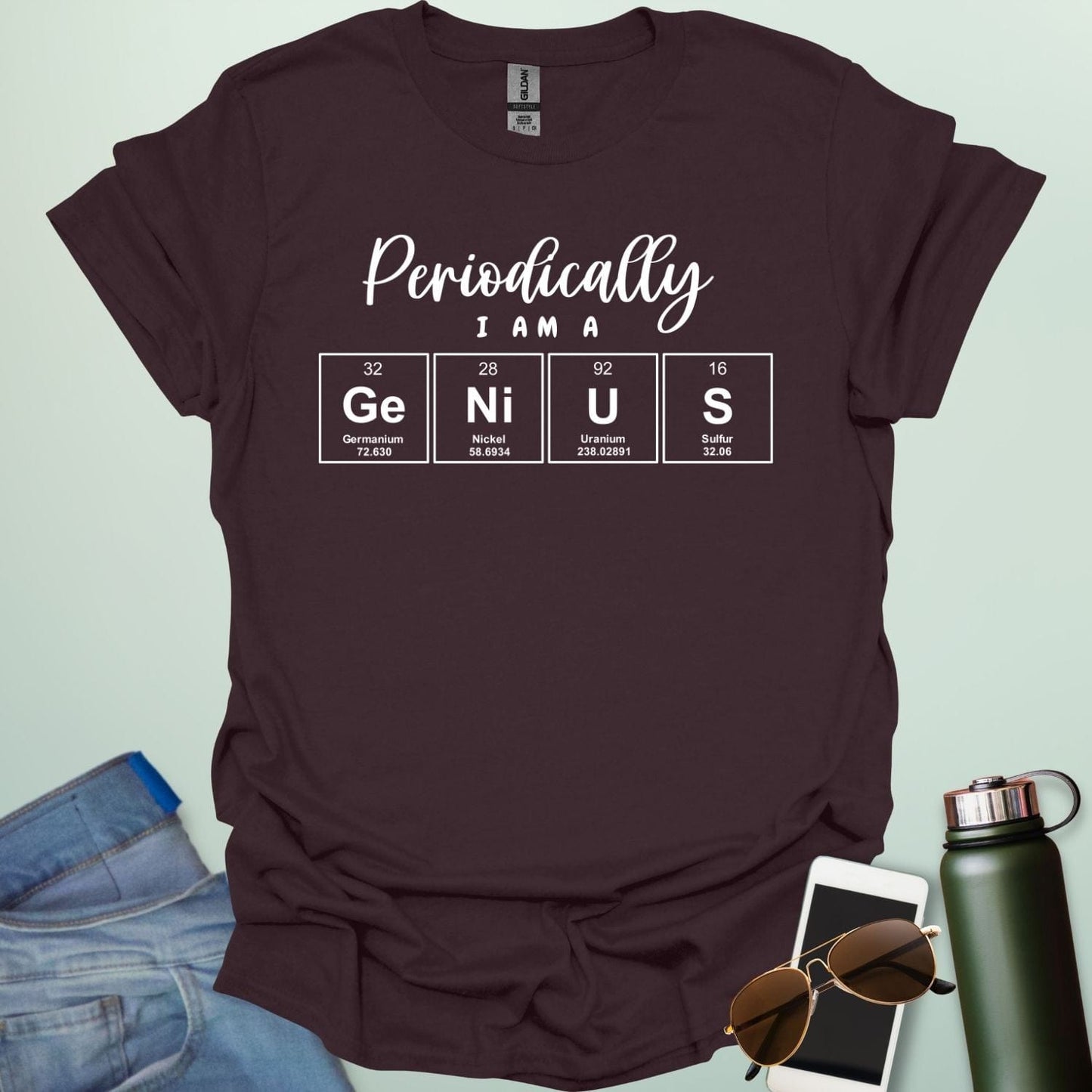 A dark chocolate t-shirt with the text 'Periodically I Am A Genius,' spelled out with the periodic table elements Ge, Ni, U, and S.