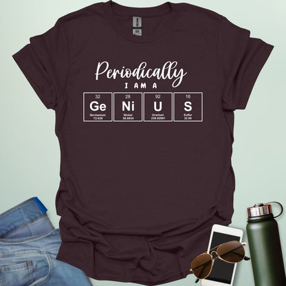 A dark chocolate t-shirt with the text 'Periodically I Am A Genius,' spelled out with the periodic table elements Ge, Ni, U, and S.