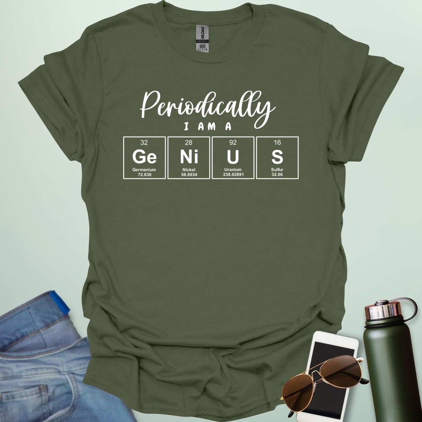 A military green t-shirt with the text 'Periodically I Am A Genius,' spelled out with the periodic table elements Ge, Ni, U, and S.