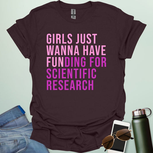A dark chocolate t-shirt with the phrase 'Girls just wanna have funding for scientific research' in a bold, pink sans-serif font.