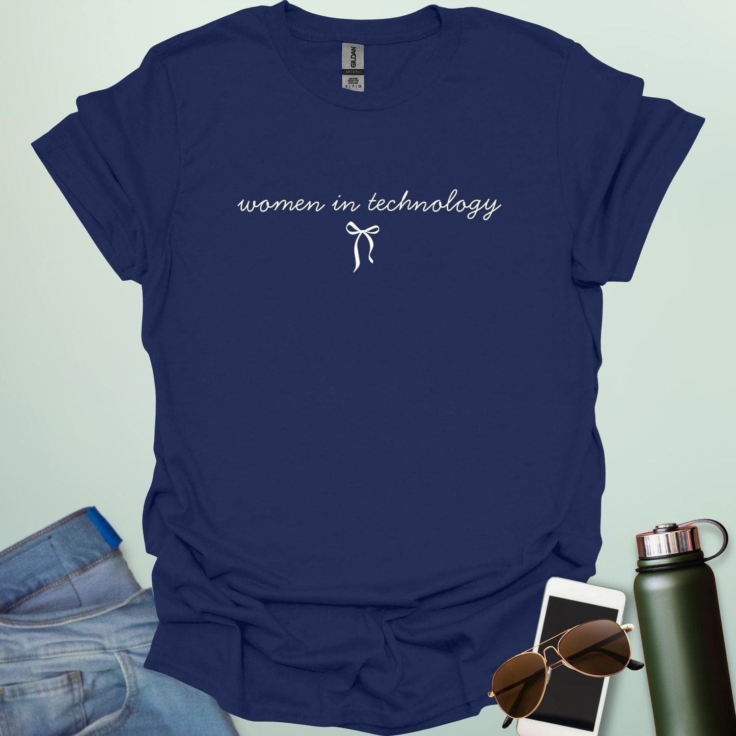 A navy blue t-shirt with the phrase 'women in technology' in an elegant cursive font, with a small bow underneath.
