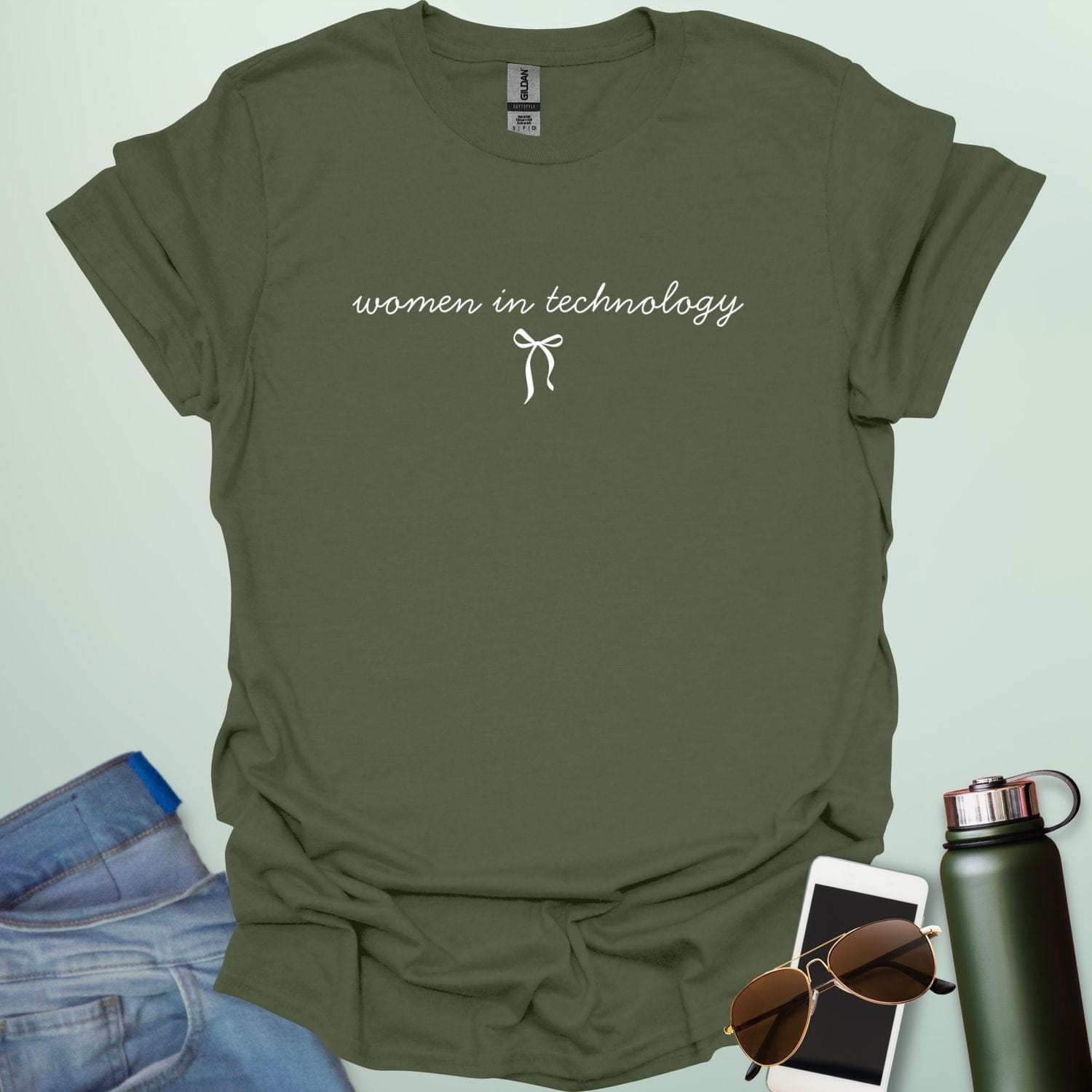 A military green t-shirt with the phrase 'women in technology' in an elegant cursive font, with a small bow underneath.
