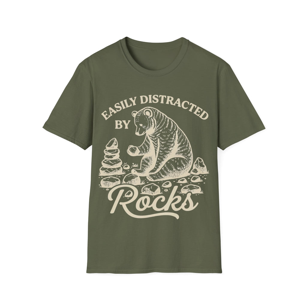 Linocut-style illustration of a bear sitting down examining a stone beside a cairn stack, framed by text reading 'EASILY DISTRACTED BY ROCKS'.