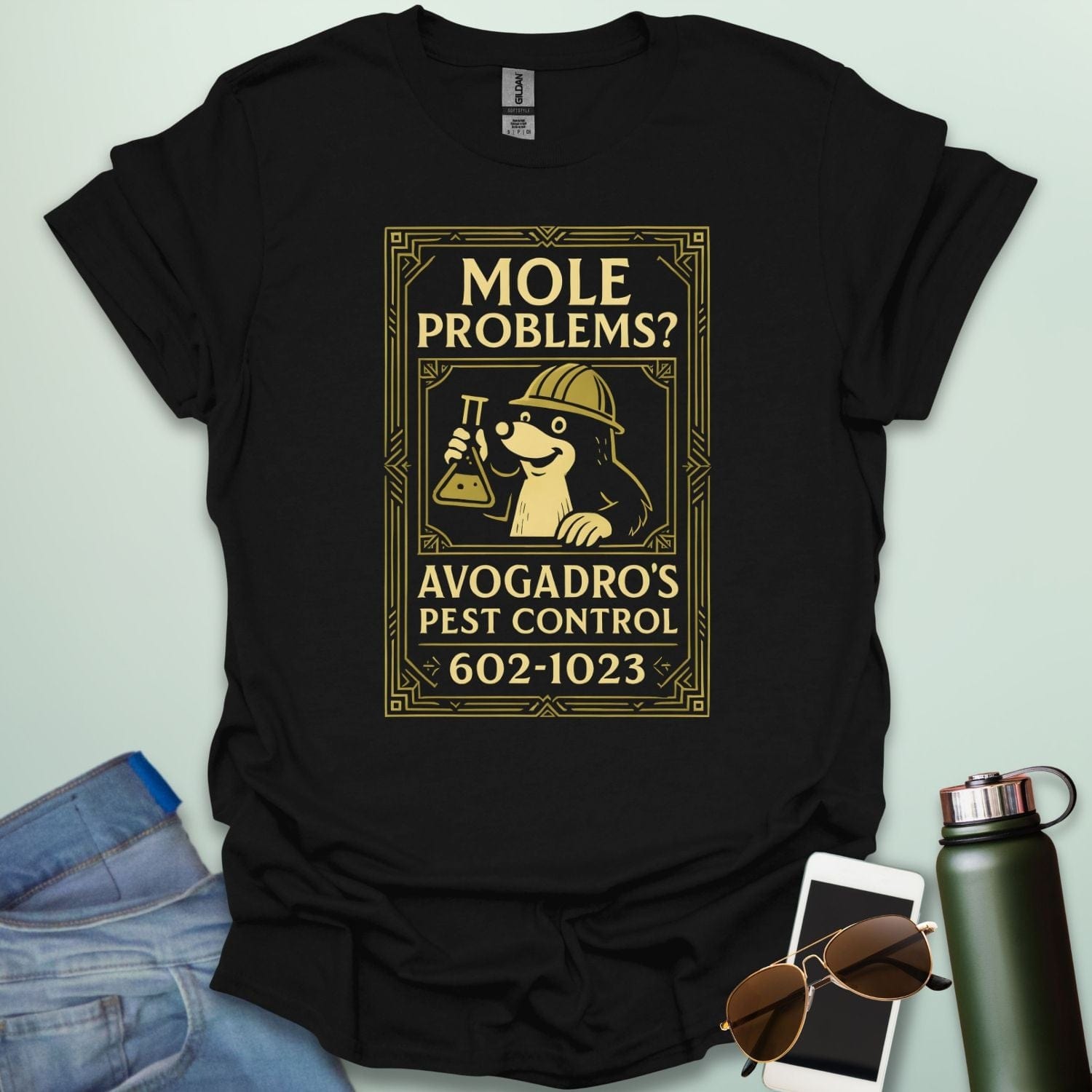 A black t-shirt designed like a vintage pest control ad with a mole holding a beaker and the text 'Mole Problems? Avogadro's Pest Control' and the number 602-1023.