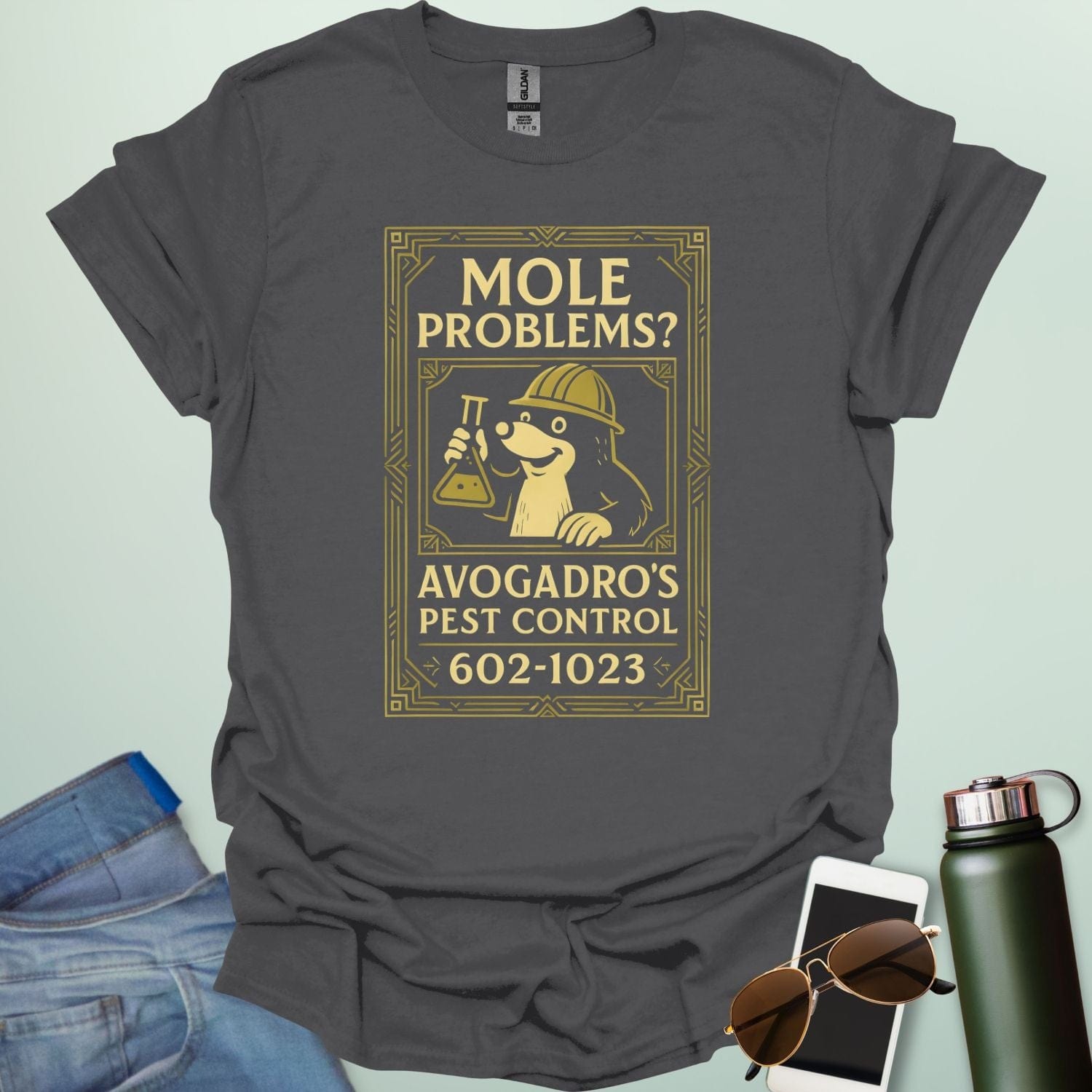 A charcoal grey t-shirt designed like a vintage pest control ad with a mole holding a beaker and the text 'Mole Problems? Avogadro's Pest Control' and the number 602-1023.