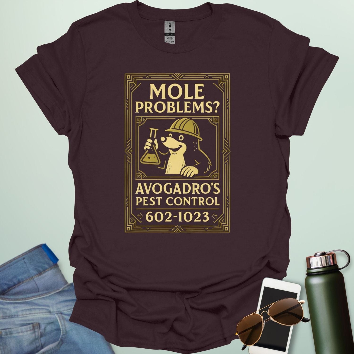 A dark chocolate t-shirt designed like a vintage pest control ad with a mole holding a beaker and the text 'Mole Problems? Avogadro's Pest Control' and the number 602-1023.