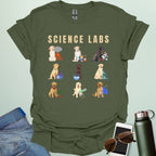 A military green t-shirt with the text 'SCIENCE LABS' and a grid of nine illustrations of Labrador Retrievers in various science-themed scenarios.