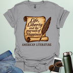 A sport grey t-shirt with a vintage-style scroll and quill pen, and the text 'Life, Liberty and the pursuit of Happiness' and 'American Literature.'