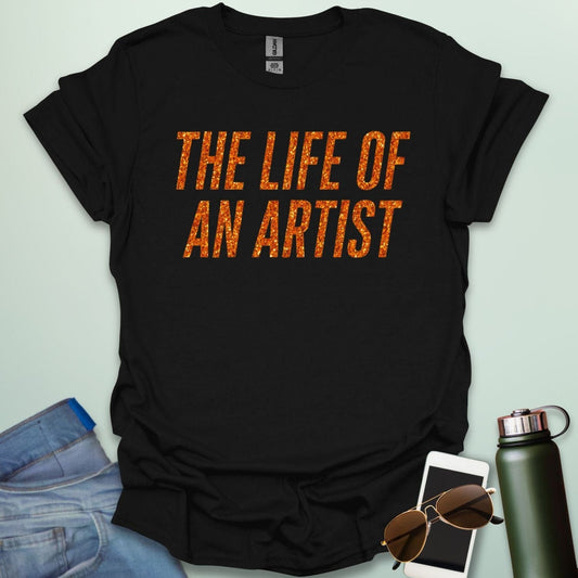 A black t-shirt with the bold, distressed text 'THE LIFE OF AN ARTIST.'