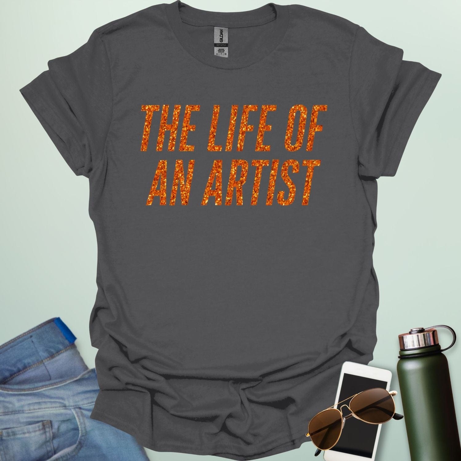 A charcoal grey t-shirt with the bold, distressed text 'THE LIFE OF AN ARTIST.'