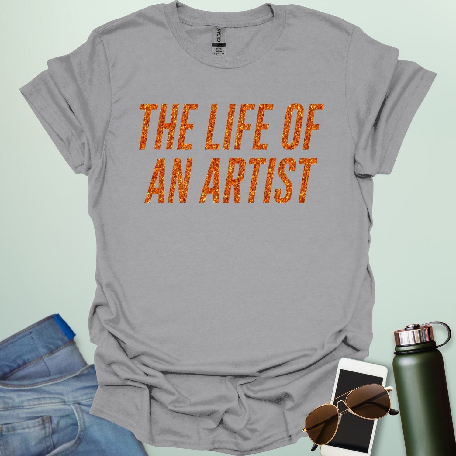 An ice grey t-shirt with the bold, distressed text 'THE LIFE OF AN ARTIST.'